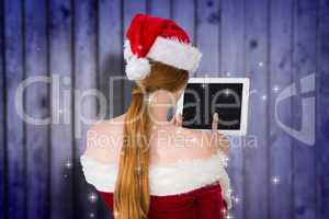 Composite image of pretty santa girl using tablet pc