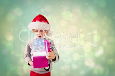 Composite image of festive boy holding a gift