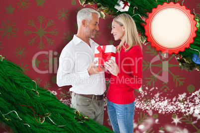 Composite image of loving couple with gift