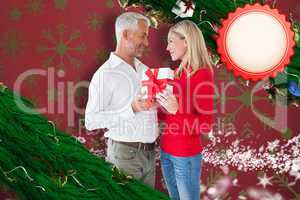 Composite image of loving couple with gift