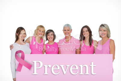Composite image of smiling women wearing pink for breast cancer