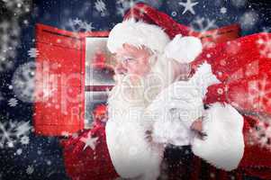 Composite image of santa claus carrying sack