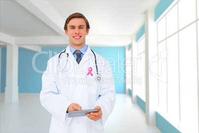 Composite image of young doctor using tablet pc