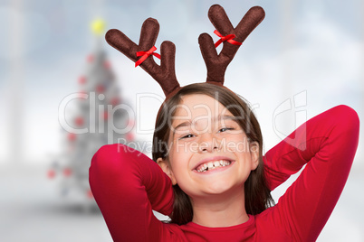 Composite image of festive little girl wearing antlers