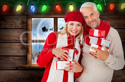 Composite image of happy festive couple with gifts