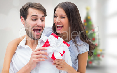 Composite image of woman surprising boyfriend with gift