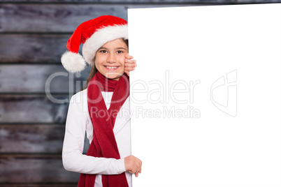 Composite image of festive little girl showing card