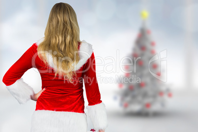 Composite image of pretty girl in santa outfit holding gift