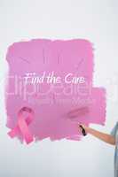 Composite image of woman painting her wall pink