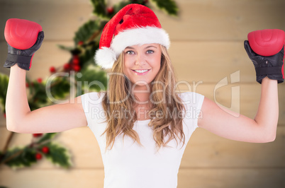 Composite image of festive blonde with boxing gloves