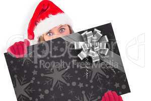 Composite image of festive blonde holding a poster