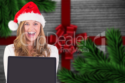 Composite image of festive blonde showing a laptop Composite image of festive blonde showing a laptop