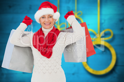 Composite image of festive woman holding shopping bags