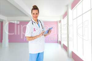 Composite image of pretty nurse using tablet pc