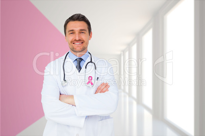 Composite image of handsome young doctor with arms crossed