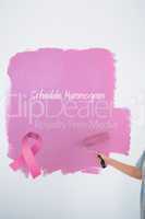 Composite image of woman painting her wall pink