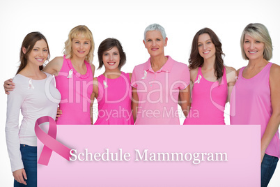 Composite image of happy women wearing pink for breast cancer aw