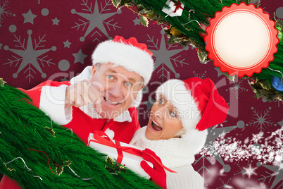 Composite image of festive mature couple holding gift Composite image of festive mature couple holding gift