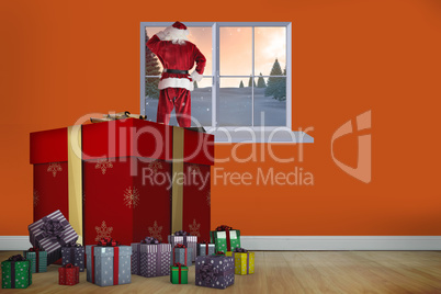 Composite image of santa standing on giant present