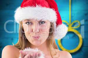 Composite image of festive blonde blowing a kiss