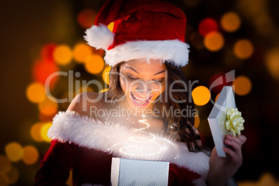 Composite image of sexy santa girl opening gift