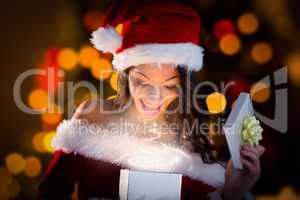 Composite image of sexy santa girl opening gift