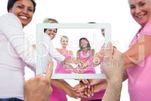 Composite image of hand holding tablet pc