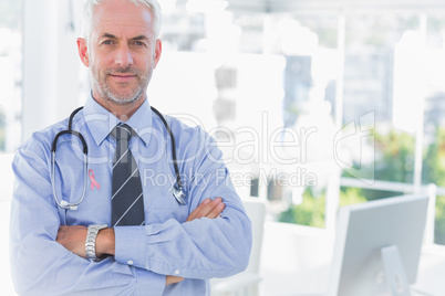 Composite image of doctor with arms crossed