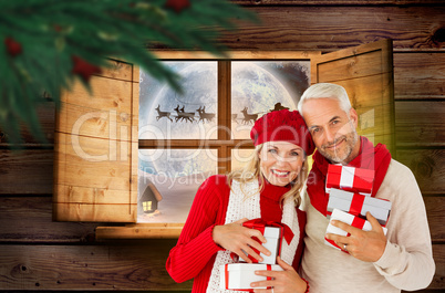 Composite image of happy festive couple with gifts