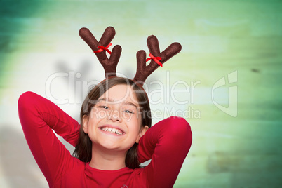 Composite image of festive little girl wearing antlers