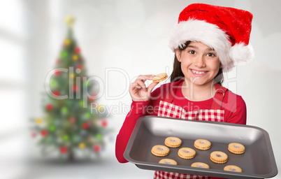 Composite image of festive little girl offering cookies