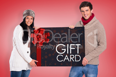 Composite image of young couple holding a poster