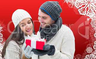 Composite image of winter couple holding gift