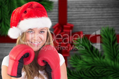 Composite image of festive blonde with boxing gloves