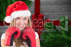 Composite image of festive blonde with boxing gloves