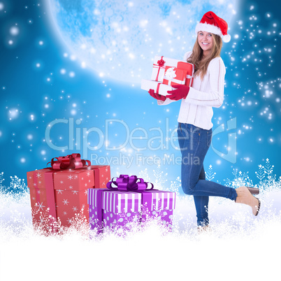 Composite image of festive blonde holding pile of gifts