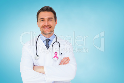 Composite image of handsome young doctor with arms crossed