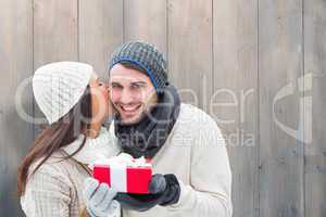 Composite image of winter couple holding gift