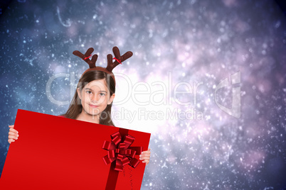 Composite image of festive little girl showing card