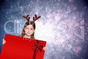 Composite image of festive little girl showing card