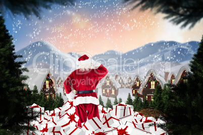 Composite image of santa standing on pile of gifts