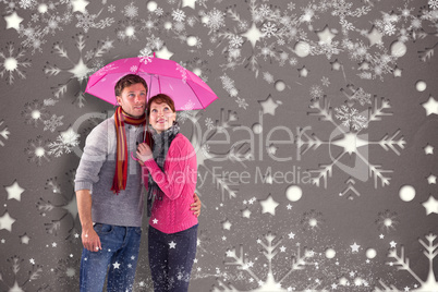 Couple standing underneath an umbrella