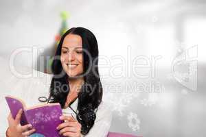 Composite image of smiling woman reading a book