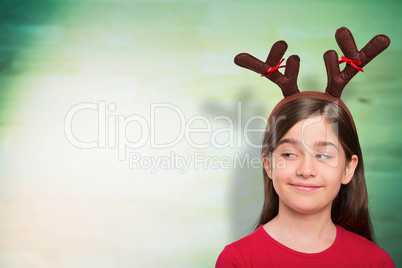 Composite image of festive little girl wearing antlers