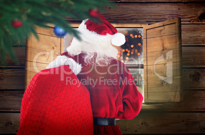 Composite image of santa claus carrying sack