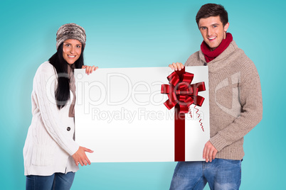 Composite image of young couple holding a poster