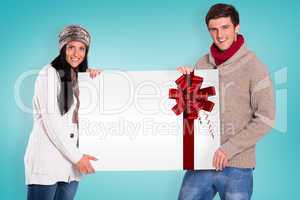 Composite image of young couple holding a poster