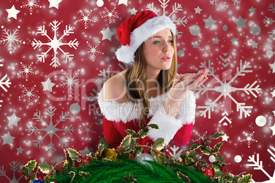 Composite image of sexy santa girl blowing over hands