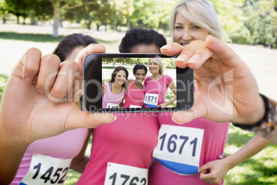 Composite image of hand holding smartphone showing