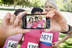 Composite image of hand holding smartphone showing